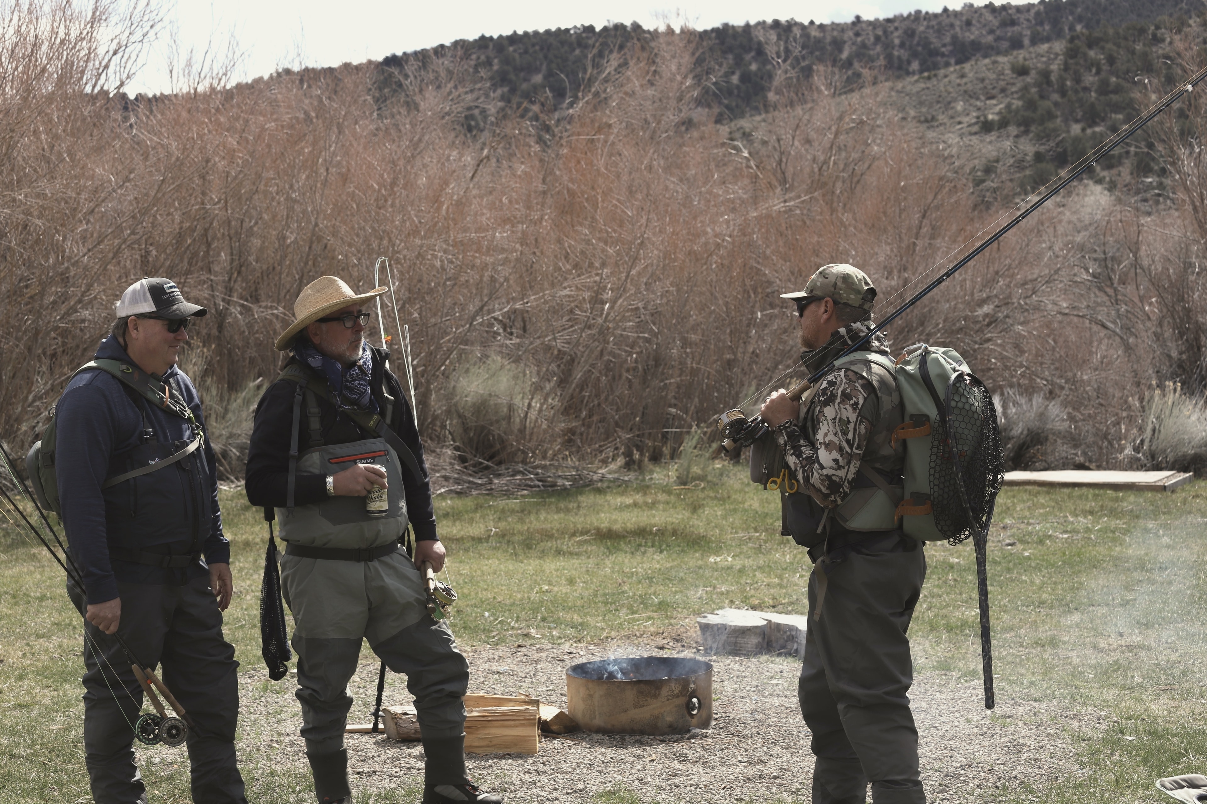 Group of anglers gathered around a fire pit at camp on the East Walker River